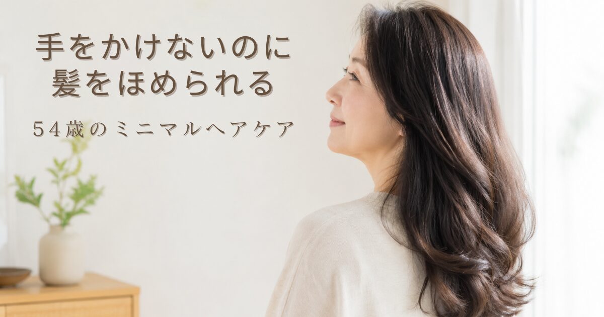 朝のやわらかな光が差し込む部屋で、つやのある健やかなロングヘアをなびかせて横を向く50代の日本人女性。洗いすぎない・手をかけないミニマルなヘアケアを紹介する、54歳ブロガーの体験記事のアイキャッチ画像。